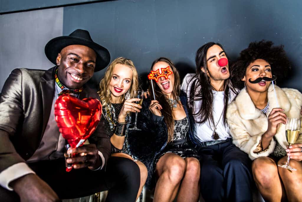 Group of people having fun with props in a photo booth.