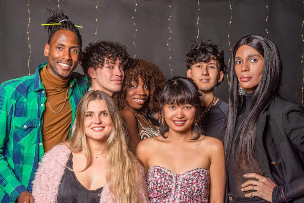 Group of people smiling in front of a decorated backdrop