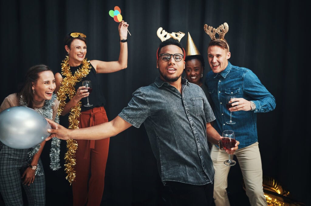 Group of people having fun with props at a photo booth.